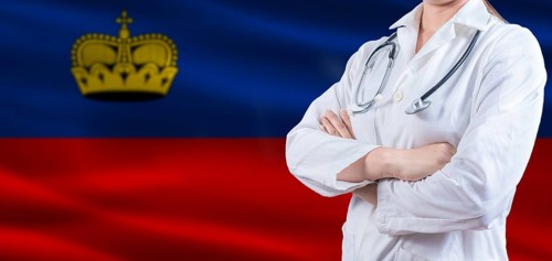 Doctor with crossed arms on Liechtenstein flag. Liechtenstein health and care concept. Female