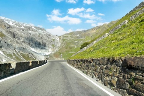 View of east ramp ascent to descent from Alpine pass Stelvio Stilfserjoch mountain road above tree