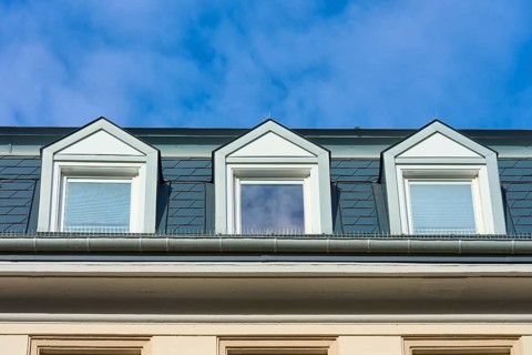 Three skylights under a clear blue sky, modern architecture with symmetrical structures, Freiburg