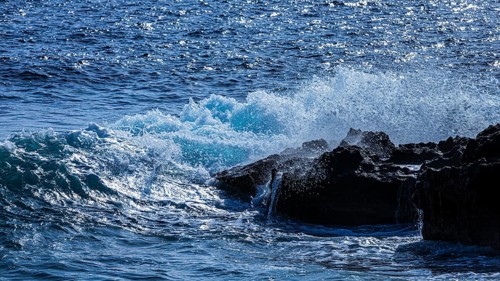 Rugged rocky coastline and foaming spray, on Stecci beach, near Capoliveri, Elba Island, Tuscan