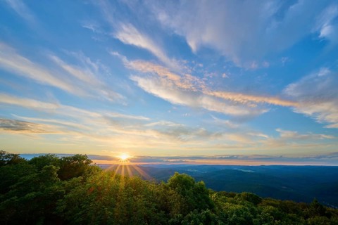 Sunset over green forests, the sky tinted in blue and orange, Katzenbuckel, Waldbrunn,