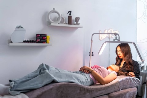 Beautician carefully examining a customer's face, preparing for a cosmetic treatment in a modern