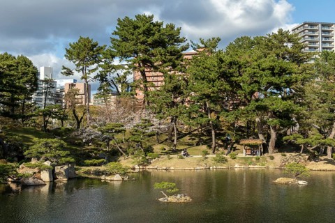 Shukkei-en with Sekisui-gan stone formation and Takuei-chi pond in spring, historical Japanese