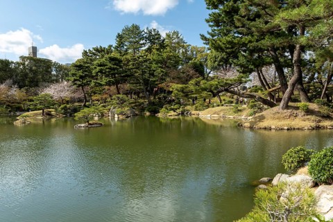 Shukkei-en with Sekisui-gan stone formation and Takuei-chi pond in spring, historical Japanese