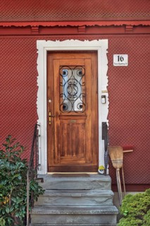 Red wooden shingle façade with wooden front door, Dornbirn, Vorarlberg, Austria
