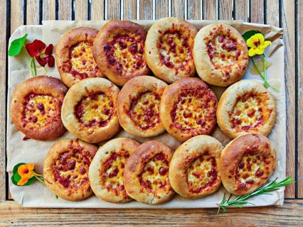 Small pizzas on baking board decorated with flowers and rosemary, bird's eye view, Lower Austria