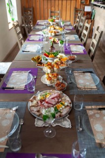 A long table with a table setting in a rustic room, decorated with flowers and crockery, Lower
