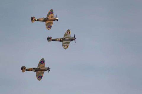 Supermarine Spitfire three warbird military aircraft in Royal air force RAF colours flying,