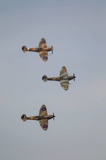Supermarine Spitfire three warbird military aircraft in Royal air force RAF colours flying,