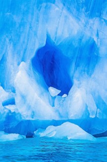 Blue ice cave on a glacier by the sea in arctic, Svalbard, Norway