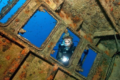 Diver looking from outside into wreck ship El Peñon, East Atlantic, Tabaita, Tenerife, Canary