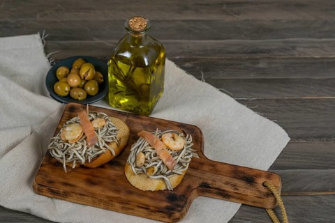 Gulas with garlic prawns in earthenware casserole dish