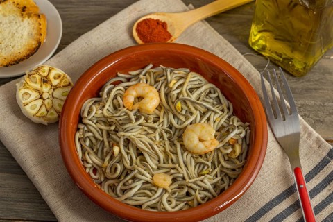 Gulas with garlic prawns in earthenware casserole dish