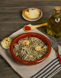 Gulas with garlic prawns in earthenware casserole dish