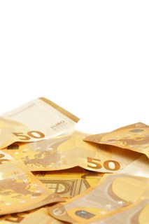 Scattered fifty euro banknotes forming a corner frame on a white background, ideal for finance and