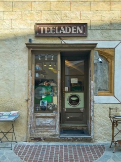 Entrance to a small, cosy tea shop in an old town with decorative shop window Mödling Lower Austria