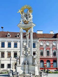 Baroque monument with ornate columns and figures on a Trinity Column Old Town Krems Wachau