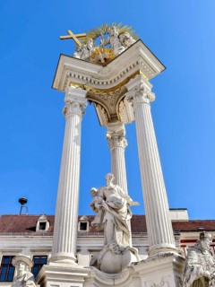 Magnificent monument with columns and statues under a bright blue sky Trinity Column Old Town Krems