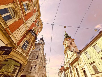View of ornate historic buildings of a city under a sunny sky Herz Jesu Kirche Graz Styria Austria