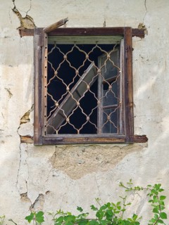 Old window with wooden lattice in a crumbling wall, part of an abandoned building Styria Austria