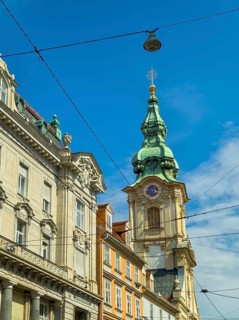 Historic building with green tower under a clear, sunny sky Herz Jesu Kirche Graz Styria Austria