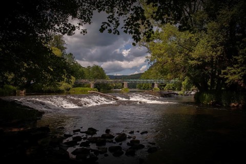 A river with a waterfall and bridge amidst trees and dark clouds Hardegg Weinviertel Lower Austria