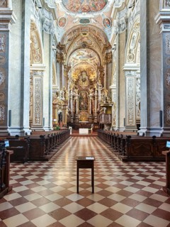 Opulently furnished nave with ornate Baroque ceiling decorations and symmetrical structure,
