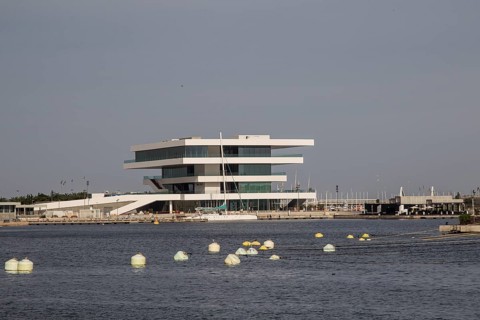 Modern building with clean lines on the water, surrounded by buoys