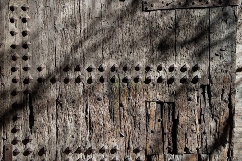 An old wooden door with visible wear and decorative nails