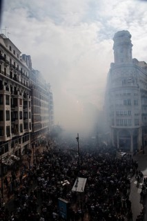 Dense crowds through a foggy city street MascletÃ¡ de Fallas