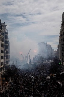 Large gathering of people in a smoky cityscape MascletÃ¡ de Fallas