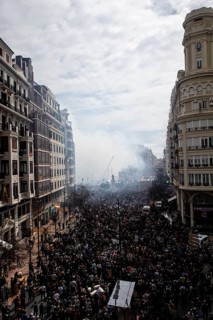 Lively street with dense crowds and billowing smoke MascletÃ¡ de Fallas