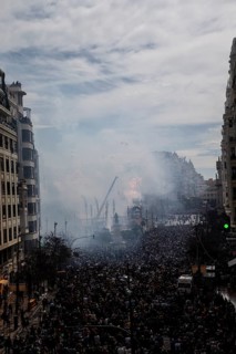 Large crowds in the city with billows of smoke and urban background MascletÃ¡ de Fallas