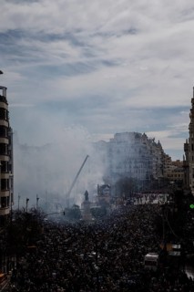 Celebration in the city with a dense crowd and smoke in the air MascletÃ¡ de Fallas