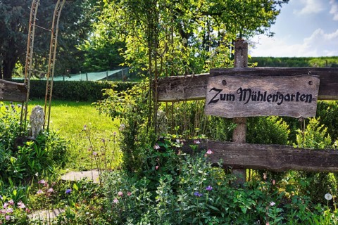 Wooden sign on the garden fence in summer, inscription, Zum MÃ¼hlengarten, country inn, historic