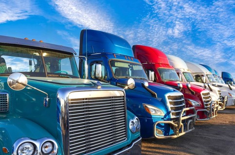 Long haul container trucks carrying commercial cargo on a parking lot ready for delivery
