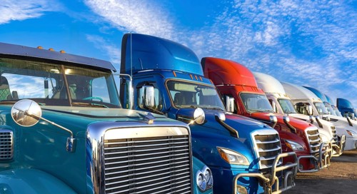 Long haul container trucks carrying commercial cargo on a parking lot ready for delivery