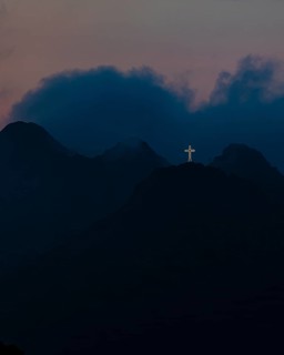 Illuminated steel cross on Monte Mar di Capanna, night shot, above Porto Azzurro, Elba Island,