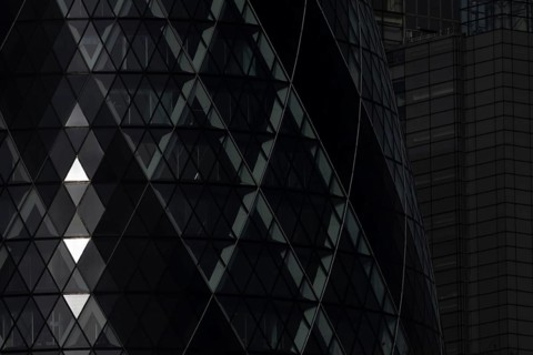 The Gherkin skyscraper building close up of window details with sunlight illuminating three