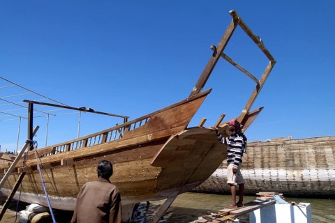 New dhow under construction, shipyard in Sur, two boat builders inspect the work progress, Sur,