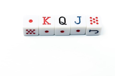 Four white dice forming the poker hand king, queen, jack, lying on a white background, ideal for