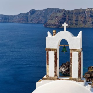 Bell tower of an orthodox church with a view of the caldera, Oia, Santorini, Cyclades, Greece
