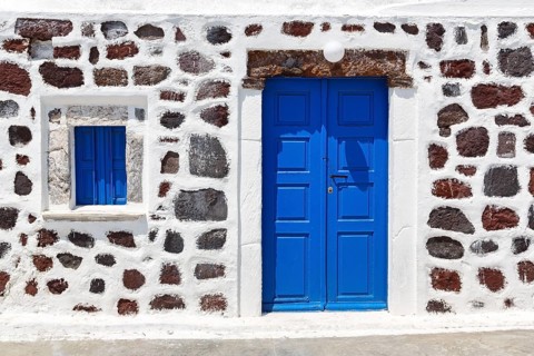 Bright blue door and blue shutter in stone wall, Chapel of Agios Nikolaos Mavrorachidi, Akrotiri,