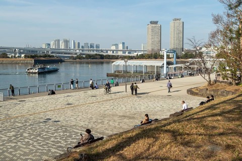Strollers on the promenade and futuristic Tokyo Cruise Water Bus Queen Emeraldas, excursion boat