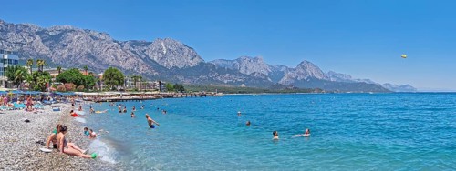 KEMER, TURKEY - JULY 5, 2025 Kemer municipality public beach with vibrant pebble under a clear,