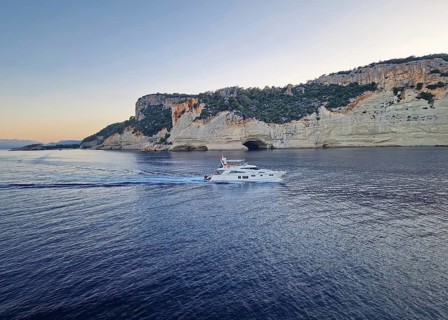 Vibrant evening seascape with a boat cruising away on the blue sea, near the Pirate Cave in Kemer