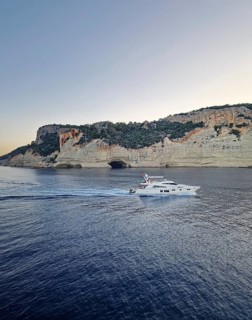 Vibrant evening seascape with a boat cruising away on the blue sea, near the Pirate Cave in Kemer