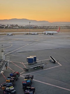 ANTALYA, TURKEY - JULY 5, 2025 Antalya airport scene at sunset with luggage being moved onto carts
