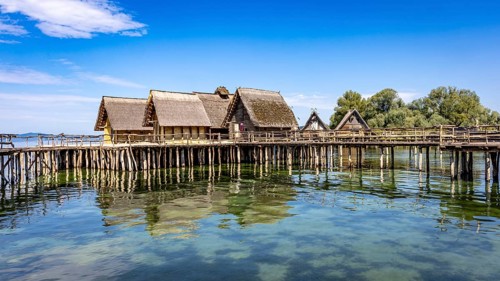 Historic pile dwellings on the shore of a lake with reflecting water, pile dwellings Unteruhldingen