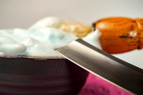 Shaving cream in bowl with straight razor and shaving brush, ready for barber to prepare customer